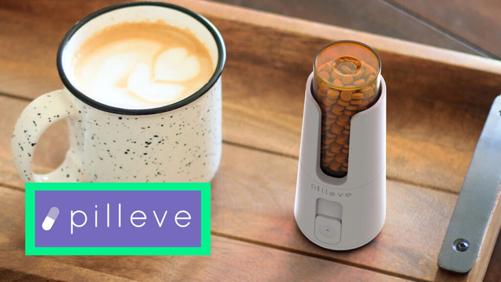 A photo of the Pilleve pill dispensing device next to a hot latte.