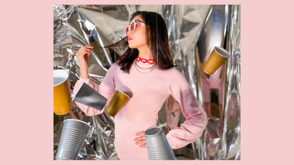 The New Norm founder Lauren Choi poses in a pink dress made from recycled plastic cups.