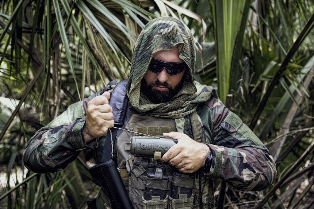 A man in camo uniform using the Quikcord to cut paracord