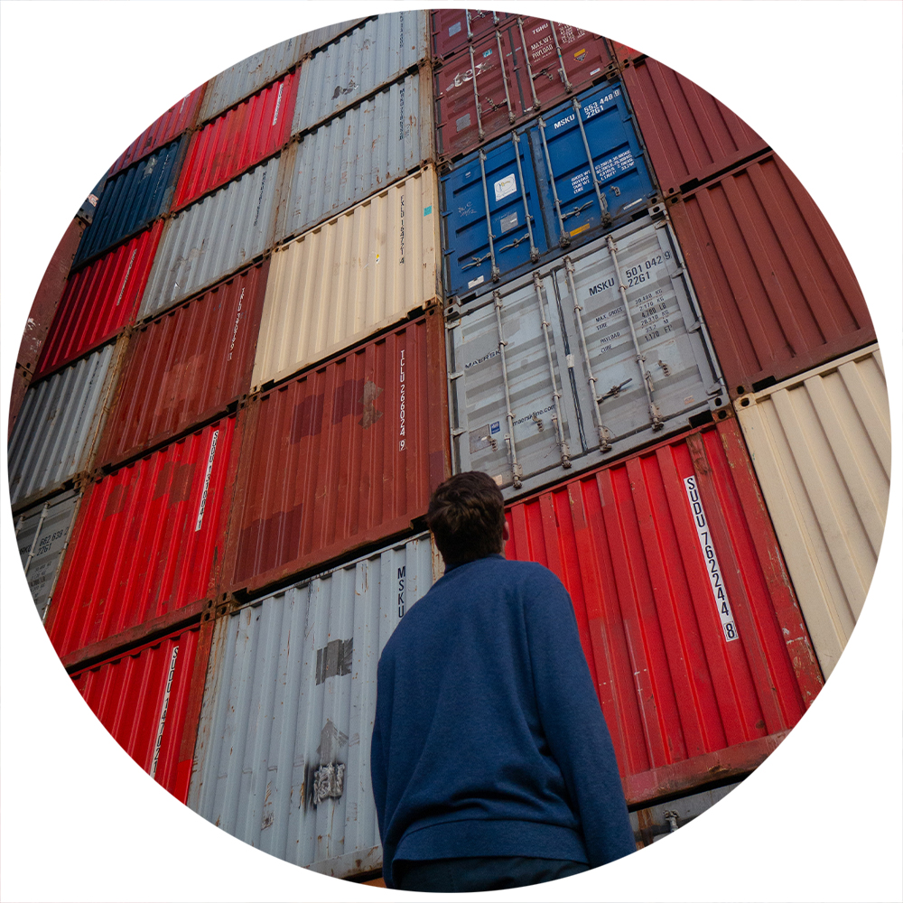 A person looking up at shipping containers. Concept of supply chain.