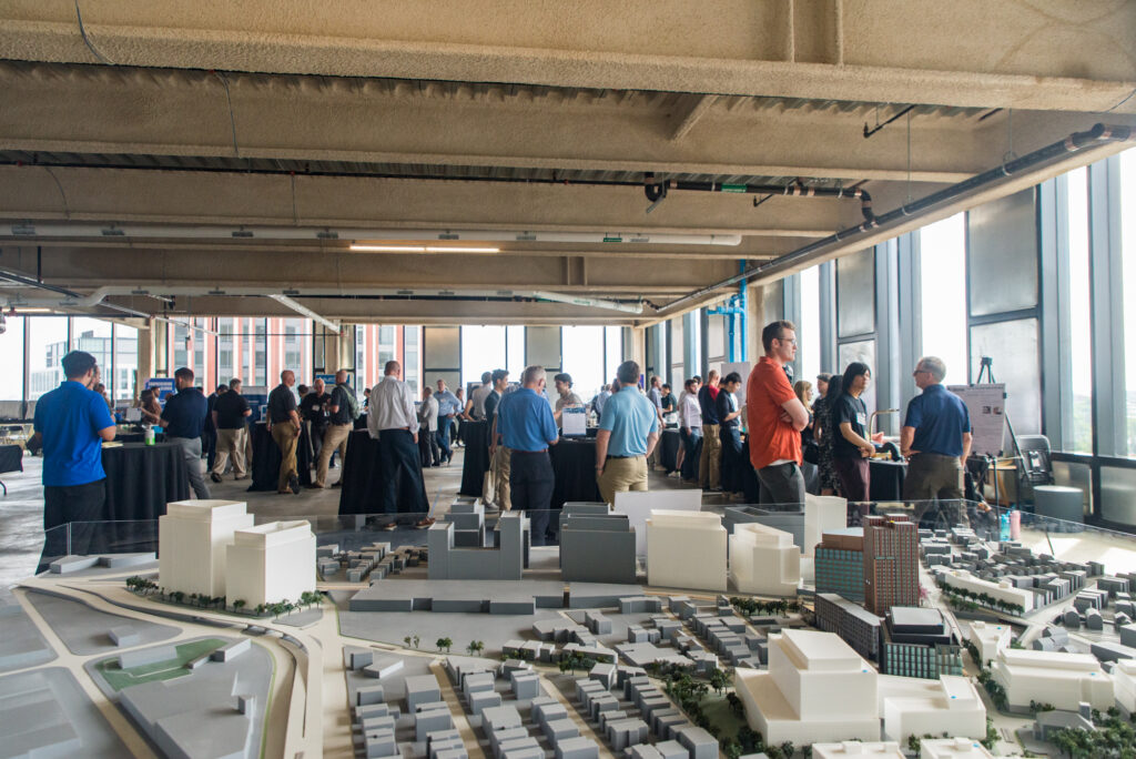 FORGE Spring Startup Showcase attendees looking at innovative physical product demos at 10 Prospect in Somerville, MA